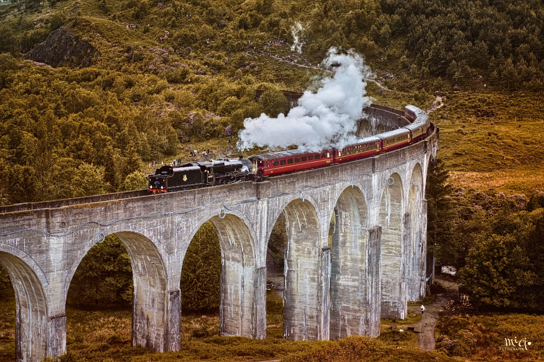Die Jacobite Dampfeisenbahn auf dem Glenfinnan Viadukt unter Dampf in Schottland