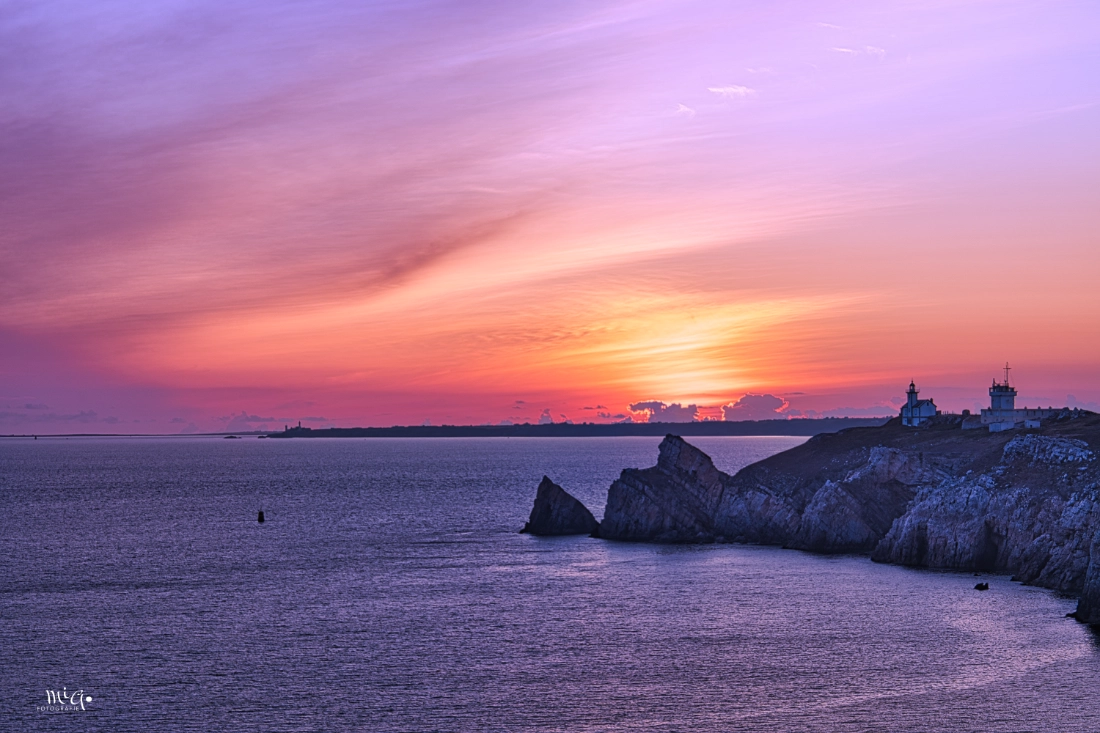 Leuchtturm an der Pointe de Toulinguet auf der Presqu'île de Crozon in der Bretagne im glutroten Sonnenuntergang ueber dem Atlantik mit Steilkueste im Vordergrund