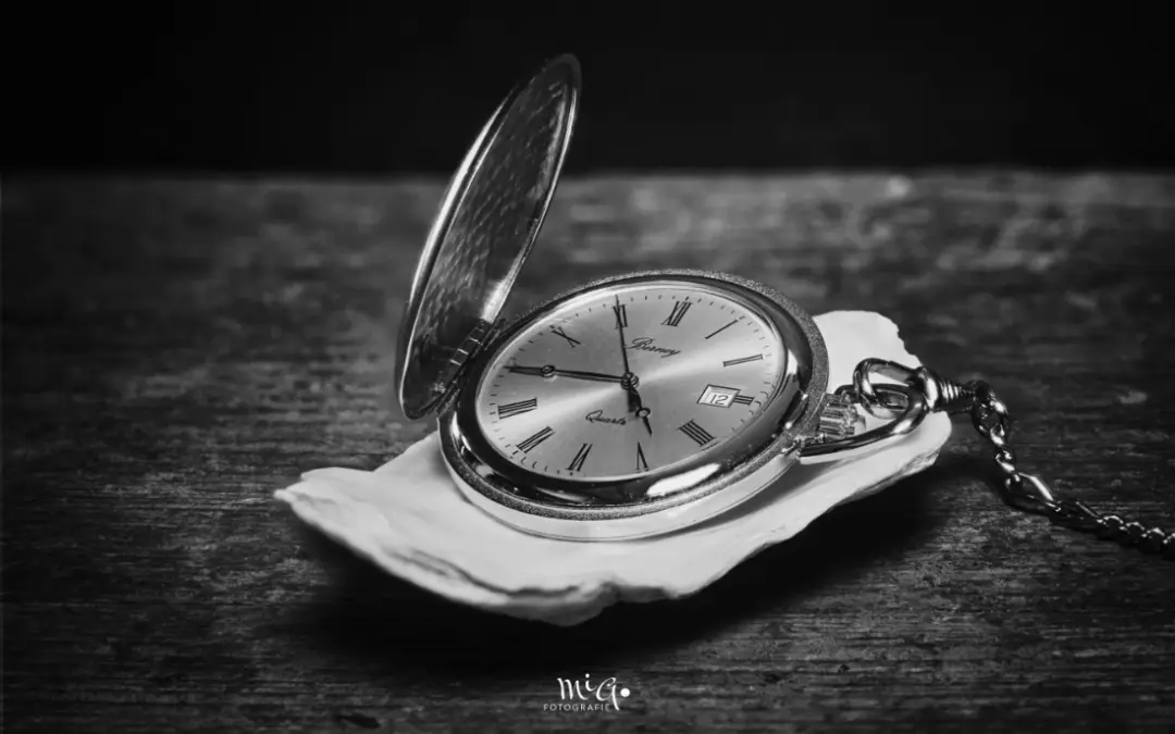 Taschenuhr auf Muschel und Holztisch sw