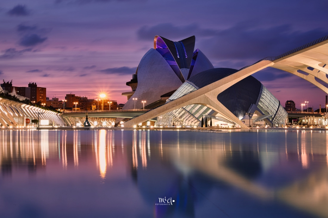 Die futuristische Architektur der Stadt der Künste und Wissenschaften in Valencia bei Dämmerung, gespiegelt im Wasserbecken.